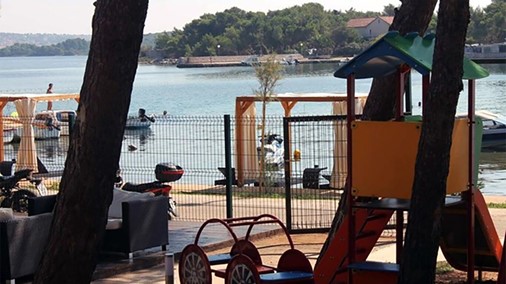 Children's playground in the Pasman campsite, with sea view.